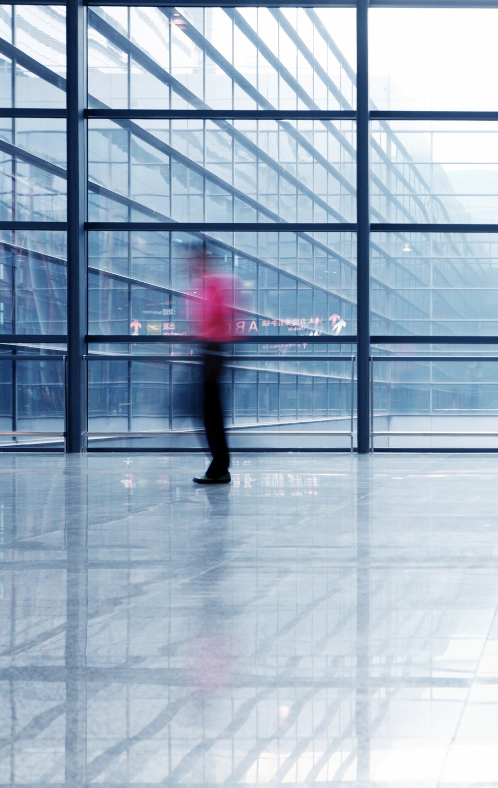 Businessperson walking through a modern glass office atrium
