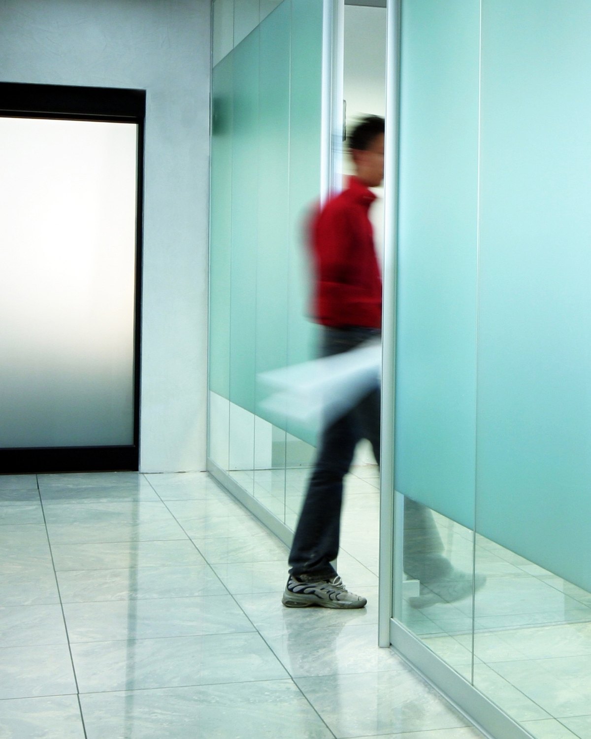Businessperson walking through a modern office corridor